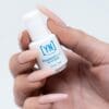 A hand with long, manicured nails holds a small white bottle labeled "Young Nails Protein Bond 0.25oz Non-Acid Adhesion.