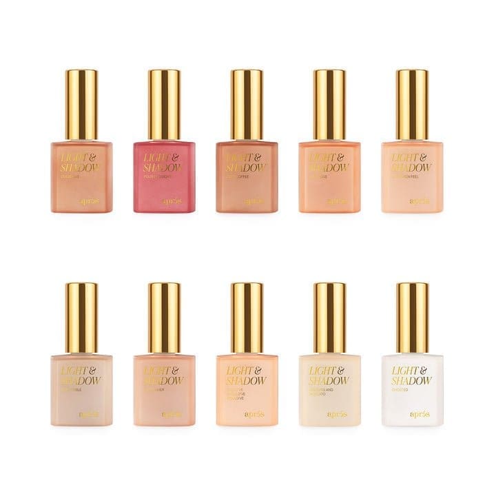 Ten bottles of Apres Light & Shadow Sheer Gel Collection 10ml are arranged in two rows, each with a gold cap, boasting varying shades from nude to pink.